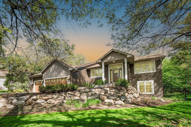 view of front of house featuring a garage and a lawn