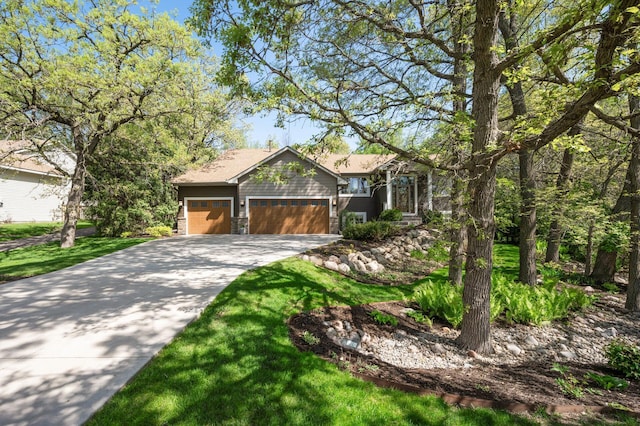 view of front of home featuring concrete driveway, a garage, and a front yard