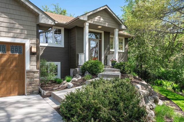 entrance to property featuring roof with shingles and stone siding