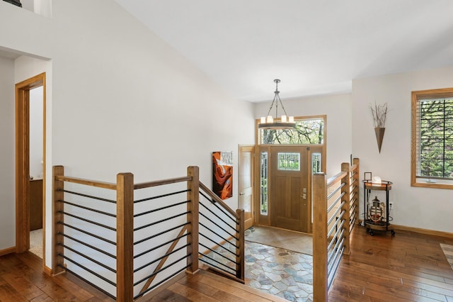 entrance foyer featuring hardwood / wood-style flooring, baseboards, and a chandelier