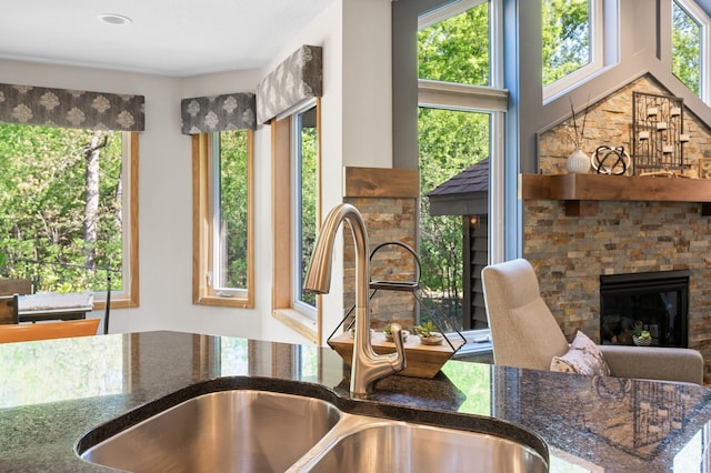 kitchen with a sink, healthy amount of natural light, and dark stone counters