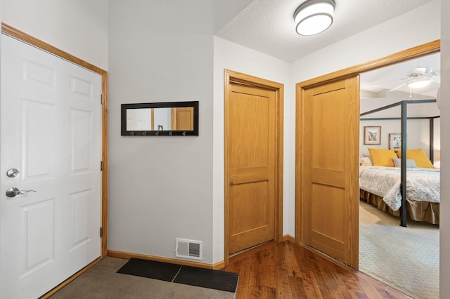 entryway featuring baseboards, wood finished floors, and ceiling fan