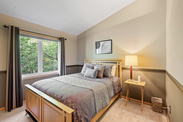 bedroom with light carpet, vaulted ceiling, and baseboards