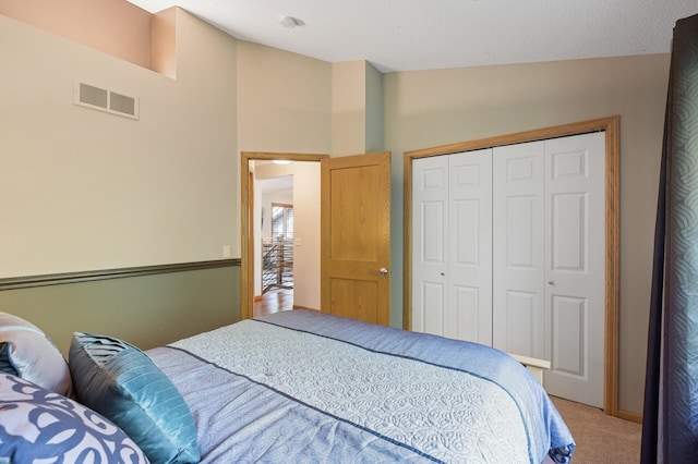 bedroom with light colored carpet, lofted ceiling, and a closet