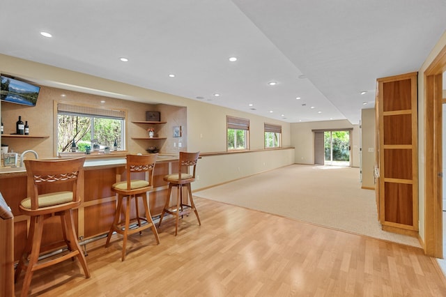 indoor bar featuring recessed lighting, light wood-style floors, and baseboards