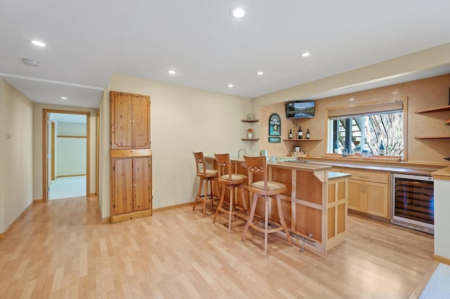 indoor wet bar featuring wine cooler, light wood finished floors, recessed lighting, and baseboards