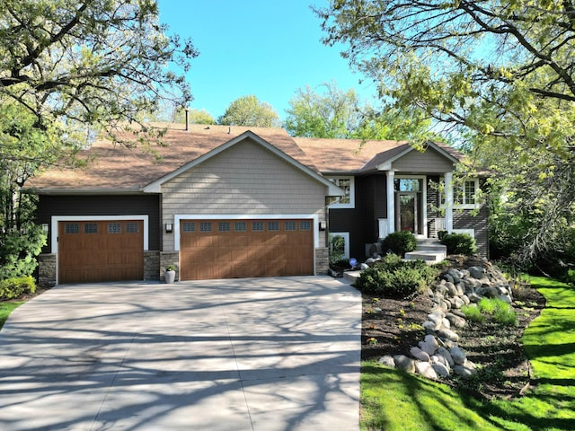 craftsman inspired home with concrete driveway, stone siding, and a garage