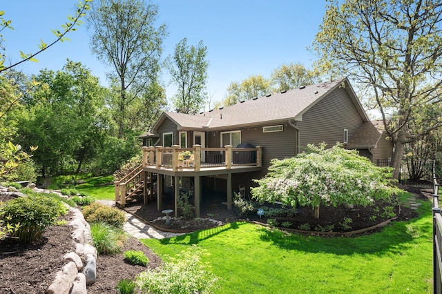 rear view of house featuring stairway, a deck, a yard, and roof with shingles