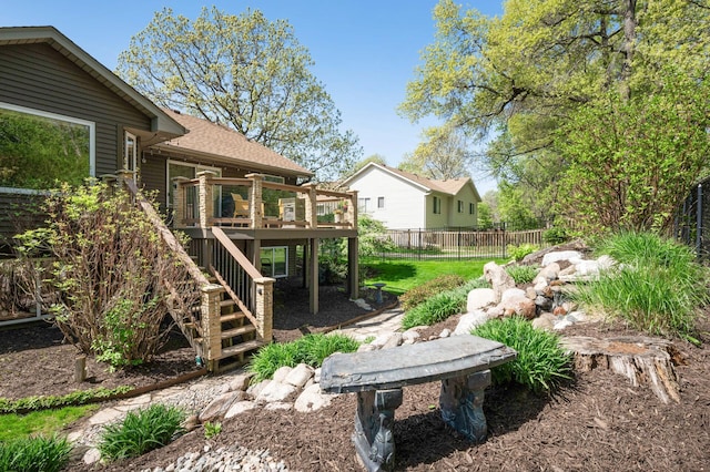 view of yard featuring fence, a wooden deck, and stairway