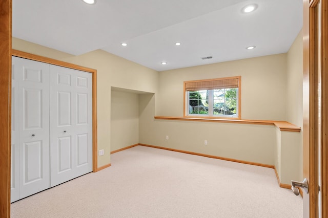 unfurnished bedroom featuring carpet flooring, baseboards, recessed lighting, and a closet