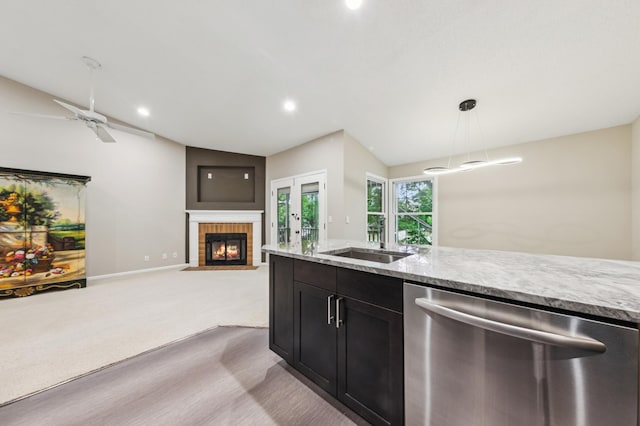10911 Rhode Island Ave S, Bloomington, MN 55438 - kitchen with stainless steel dishwasher, a fireplace, a sink, vaulted ceiling, and light stone countertops