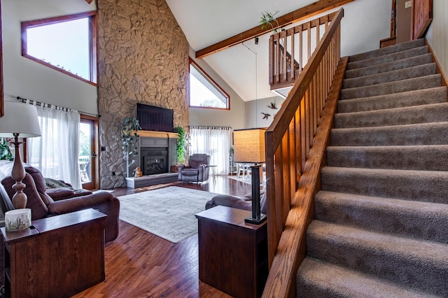 6385 13th Ave NW, Rochester, MN 55901 - living area with high vaulted ceiling, wood-type flooring, stairs, beamed ceiling, and a fireplace