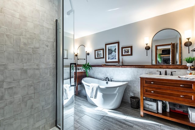 6385 13th Ave NW, Rochester, MN 55901 - bathroom featuring tile walls, vanity, a freestanding bath, a shower stall, and a wainscoted wall