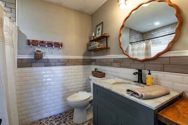 6385 13th Ave NW, Rochester, MN 55901 - bathroom featuring toilet, tile walls, wainscoting, vanity, and a shower with curtain
