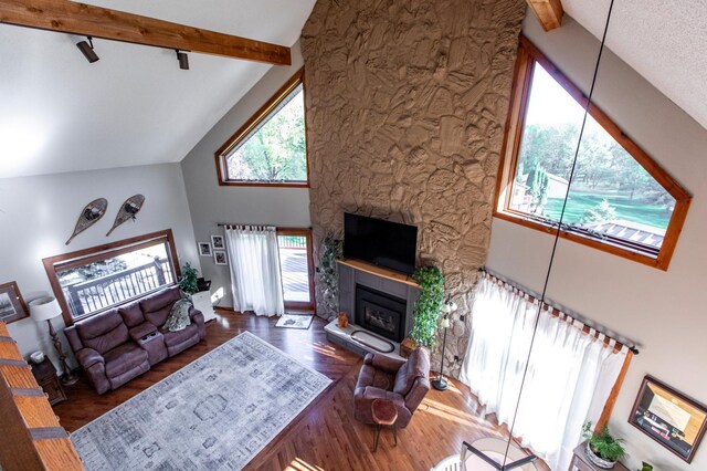6385 13th Ave NW, Rochester, MN 55901 - living area featuring high vaulted ceiling, a glass covered fireplace, beamed ceiling, and wood finished floors