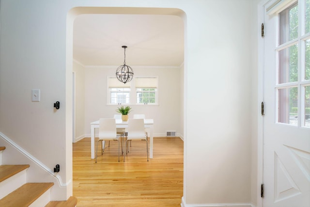 623 Fairview Ave S, Saint Paul, MN 55116 - dining space featuring light wood-style floors, a chandelier, stairway, and crown molding