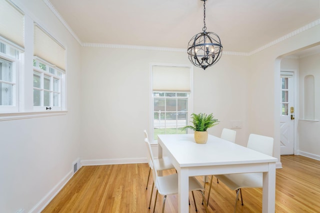 623 Fairview Ave S, Saint Paul, MN 55116 - dining room featuring a chandelier, light wood-style flooring, arched walkways, and crown molding