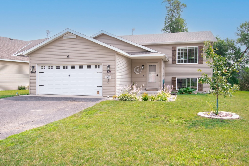 1317 Natures Trl, Alexandria, MN 56308 - split level home featuring an attached garage, asphalt driveway, and a front lawn