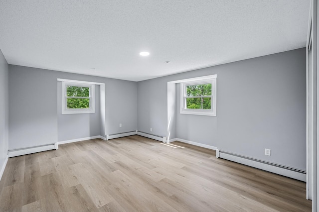 4824 Eriks Blvd, Eagan, MN 55122 - spare room with baseboard heating, healthy amount of natural light, wood finished floors, recessed lighting, and a textured ceiling