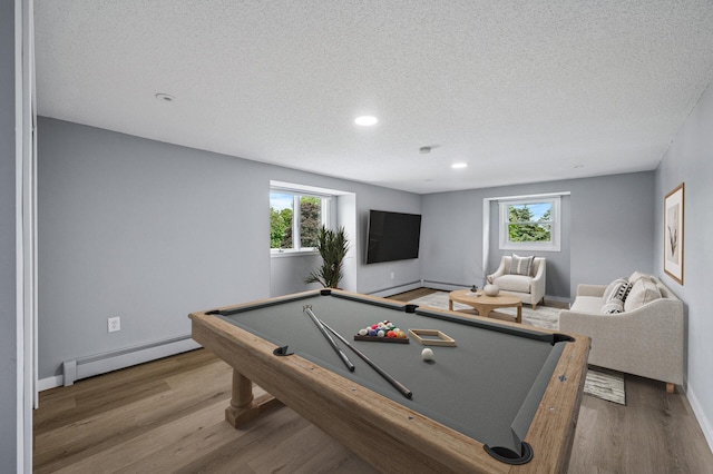 4824 Eriks Blvd, Eagan, MN 55122 - rec room featuring a baseboard heating unit, a textured ceiling, wood finished floors, healthy amount of natural light, and baseboards