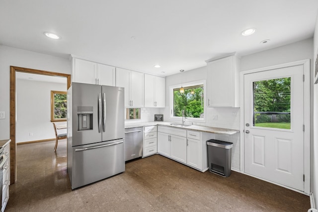 4824 Eriks Blvd, Eagan, MN 55122 - kitchen featuring appliances with stainless steel finishes, a sink, light countertops, white cabinets, and tasteful backsplash