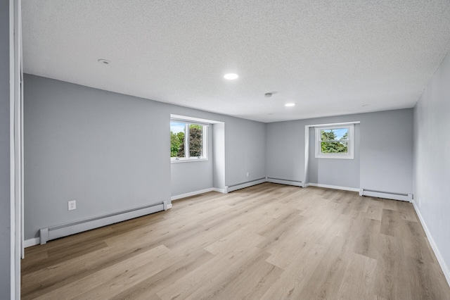 4824 Eriks Blvd, Eagan, MN 55122 - spare room featuring a baseboard heating unit, a textured ceiling, healthy amount of natural light, light wood finished floors, and recessed lighting