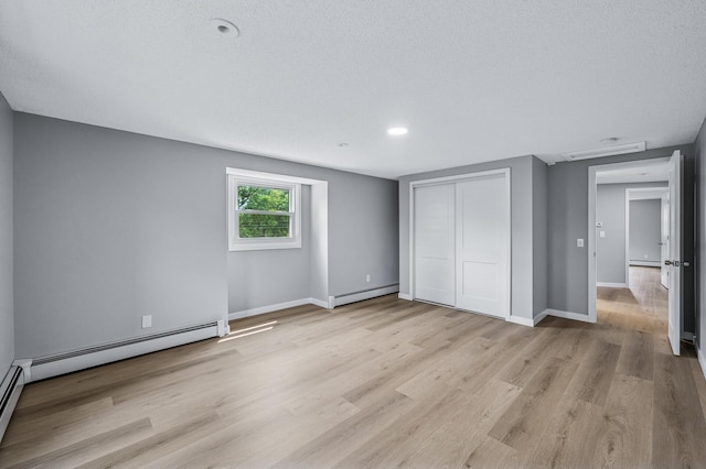 4824 Eriks Blvd, Eagan, MN 55122 - unfurnished bedroom featuring a baseboard radiator, light wood-style flooring, a closet, and a textured ceiling