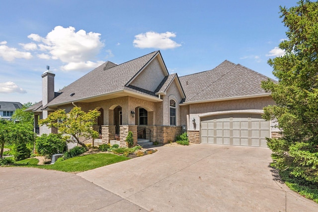 130 Stonebridge Rd, Lilydale, MN 55118 - french provincial home featuring stone siding, stucco siding, concrete driveway, a porch, and a garage