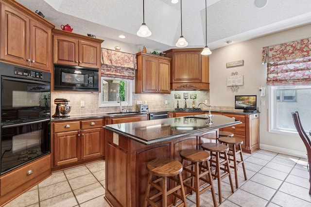 130 Stonebridge Rd, Lilydale, MN 55118 - kitchen with black appliances, a sink, a center island with sink, light tile patterned floors, and brown cabinets