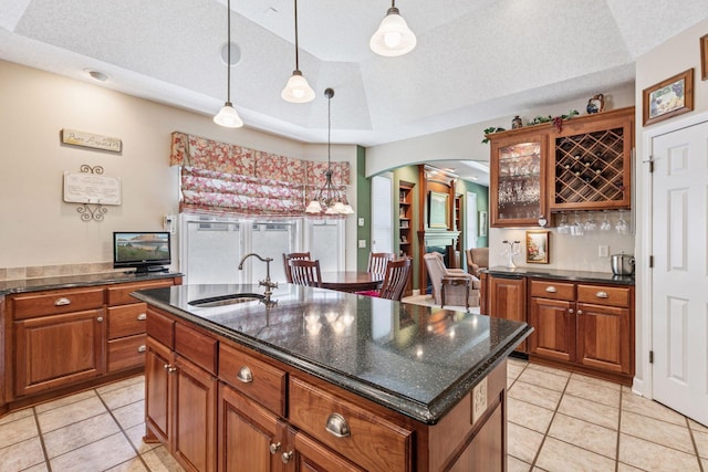 130 Stonebridge Rd, Lilydale, MN 55118 - kitchen with a sink, brown cabinets, arched walkways, light tile patterned flooring, and a textured ceiling