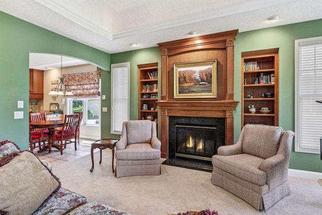 130 Stonebridge Rd, Lilydale, MN 55118 - living room featuring a high end fireplace, light colored carpet, baseboards, ornamental molding, and arched walkways