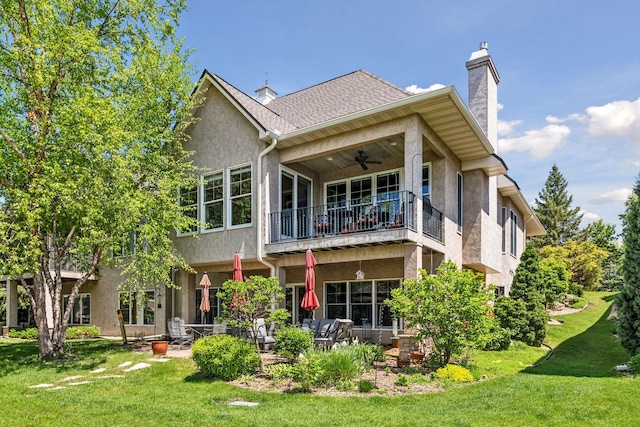 130 Stonebridge Rd, Lilydale, MN 55118 - rear view of house featuring a balcony, a ceiling fan, a chimney, a lawn, and stucco siding