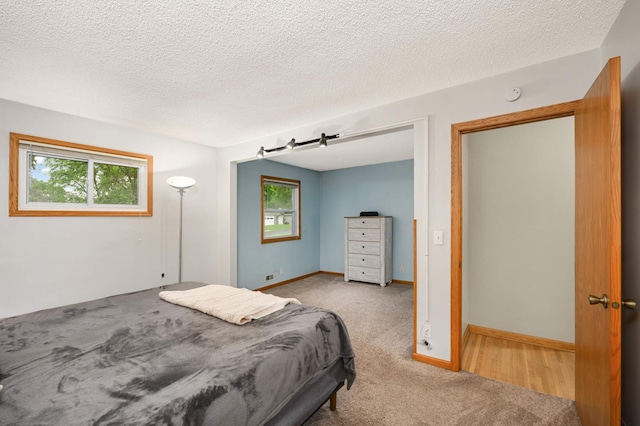 carpeted bedroom with a textured ceiling and baseboards
