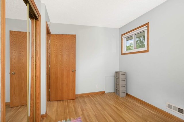 unfurnished bedroom with wood finished floors and baseboards