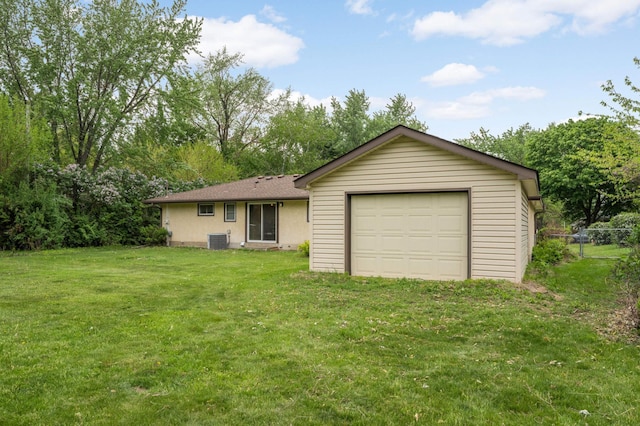 back of property with a garage and central AC