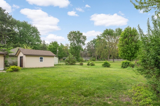 view of yard featuring an outdoor structure and view of wooded area