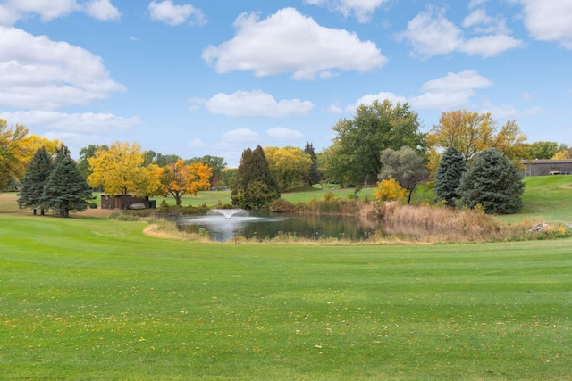 view of grassy yard featuring view of golf course and a water view