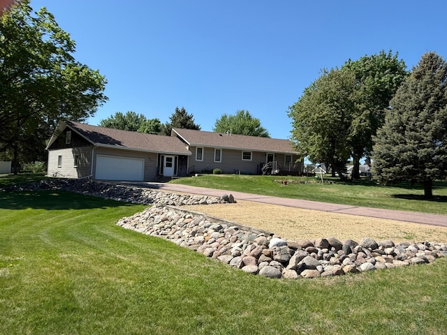 ranch-style house featuring an attached garage, a front lawn, and driveway