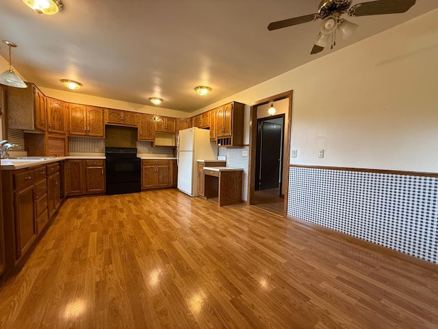 421 Oxford St W, Worthington, MN 56187 - kitchen with range, freestanding refrigerator, a sink, wood finished floors, and wainscoting