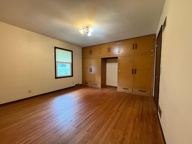 421 Oxford St W, Worthington, MN 56187 - unfurnished bedroom with wood finished floors, baseboards, and a closet
