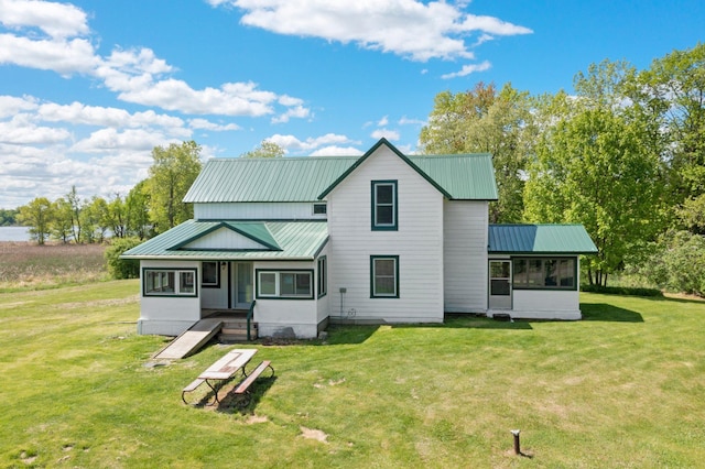 3592 Blom Lake Dr, Frederic, WI 54837 - view of front of home with a front yard, a sunroom, and metal roof