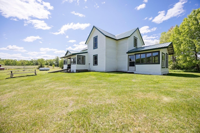 3592 Blom Lake Dr, Frederic, WI 54837 - back of property featuring a sunroom, a yard, and metal roof