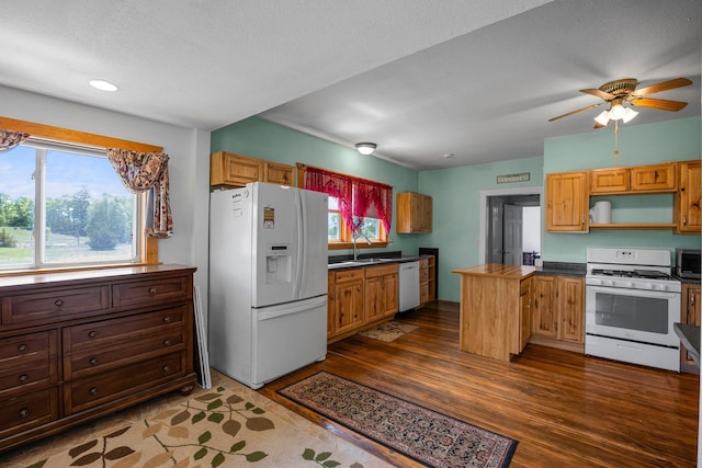 3592 Blom Lake Dr, Frederic, WI 54837 - kitchen with white appliances, a sink, dark countertops, dark wood-style floors, and recessed lighting