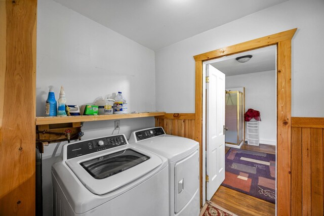 3592 Blom Lake Dr, Frederic, WI 54837 - washroom featuring washing machine and dryer, wainscoting, wooden walls, and wood finished floors