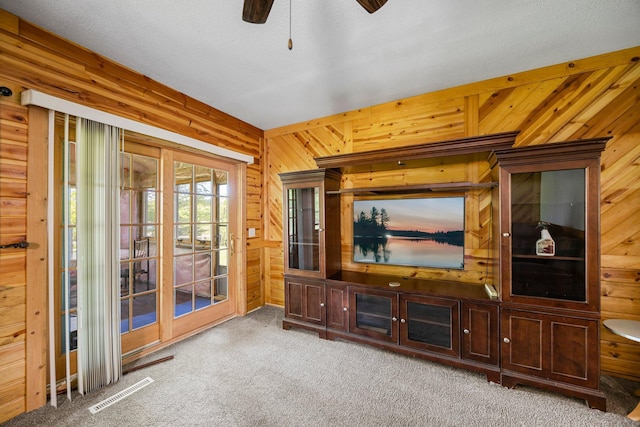 3592 Blom Lake Dr, Frederic, WI 54837 - unfurnished living room featuring carpet, wood walls, and ceiling fan