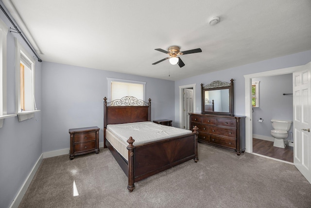 3592 Blom Lake Dr, Frederic, WI 54837 - carpeted bedroom with baseboards, connected bathroom, and ceiling fan