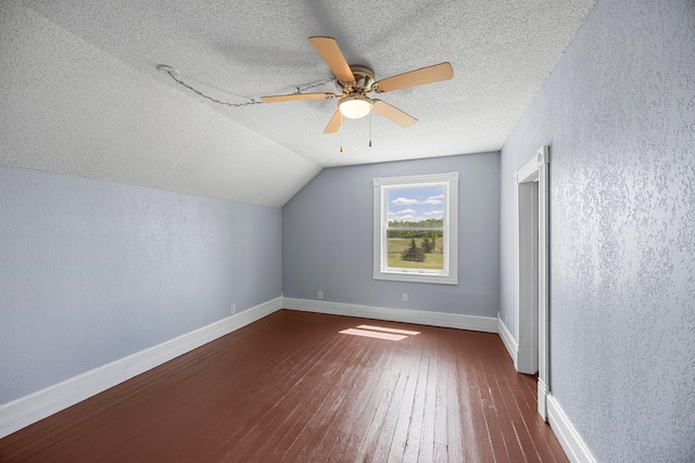 3592 Blom Lake Dr, Frederic, WI 54837 - bonus room featuring dark wood finished floors, a textured ceiling, ceiling fan, a textured wall, and vaulted ceiling
