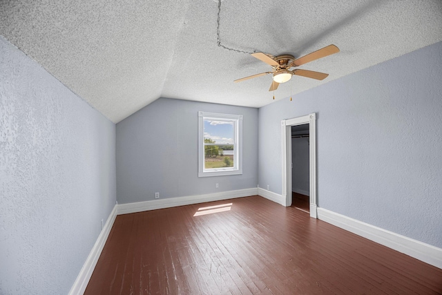 3592 Blom Lake Dr, Frederic, WI 54837 - bonus room featuring a textured wall, ceiling fan, dark wood-style flooring, a textured ceiling, and baseboards