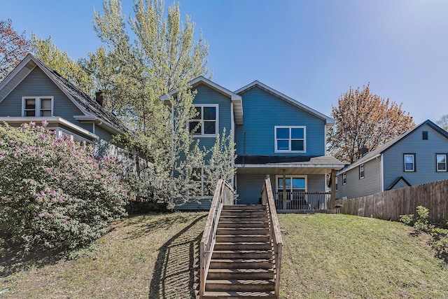 rear view of house with covered porch and stairs
