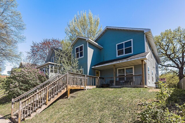 back of house featuring stairs and a yard